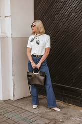 a lady in a white openwork top and a pair of blue jeans